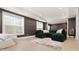Comfortable living room features a plush green sectional sofa, accent rug, and decorative wall art for a relaxing atmosphere at 4980 Wildeoak Trl, Douglasville, GA 30135