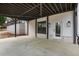 Covered patio with white brick accents, modern lighting, and a view of the wooded landscape at 4980 Wildeoak Trl, Douglasville, GA 30135