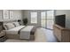 Cozy bedroom featuring a large bed, sliding glass doors to balcony, and wood flooring at 1 Biscayne Nw Dr # 410, Atlanta, GA 30309