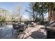 Outdoor dining area with a gas grill, tables, chairs and a wooded view at 1 Biscayne Nw Dr # 410, Atlanta, GA 30309