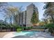A large swimming pool sits in front of the building with mature trees and landscaping around the outside of the pool at 1 Biscayne Nw Dr # 410, Atlanta, GA 30309