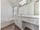 Bathroom featuring a bathtub, double vanity, quartz countertop, and bright lighting, creating a functional and inviting space at 423 Eagle Ridge Trl, Canton, GA 30114
