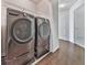Modern laundry room featuring side-by-side washer and dryer, combined with stylish hardwood floors for added convenience at 423 Eagle Ridge Trl, Canton, GA 30114