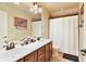 Well-lit bathroom with a double sink vanity, framed mirror, and a shower with a curtain at 4540 Brighton View Trl, Cumming, GA 30040