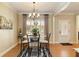 Dining area featuring a decorative chandelier, a small table, a large window, and wood floors at 4540 Brighton View Trl, Cumming, GA 30040