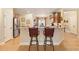 An open concept kitchen featuring an eat-in bar with granite countertops and stainless steel appliances at 4540 Brighton View Trl, Cumming, GA 30040