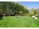 Serene backyard features lush green grass, mature trees, and charming stone benches at 2500 Peachtree Nw Rd # 207S, Atlanta, GA 30305