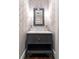 Stylish powder room with patterned wallpaper, marble countertop, and elegant mirror at 2500 Peachtree Nw Rd # 207S, Atlanta, GA 30305