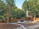 Lush backyard featuring a custom ping pong table set upon pavers and mature trees at 152 Vinings Lake Ct, Mableton, GA 30126
