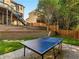 Beautifully landscaped backyard featuring a ping pong table and a patio area perfect for outdoor fun at 152 Vinings Lake Ct, Mableton, GA 30126