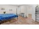 Bedroom featuring a wood-look floor, blue blanket on bed, neutral-colored walls, and open closet at 152 Vinings Lake Ct, Mableton, GA 30126