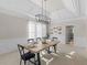 Elegant dining room with modern chandelier, wainscoting, and neutral carpet flooring, ideal for hosting dinner parties at 152 Vinings Lake Ct, Mableton, GA 30126
