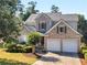 Charming two-story home with brick accents, lush landscaping, and a practical two-car garage at 152 Vinings Lake Ct, Mableton, GA 30126