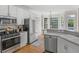 Modern kitchen with stainless steel appliances, hardwood floors, and ample counter space, perfect for culinary creations at 152 Vinings Lake Ct, Mableton, GA 30126