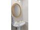 Cozy half bathroom featuring pedestal sink, oval mirror, and decorative gold trim to impress your guests at 152 Vinings Lake Ct, Mableton, GA 30126
