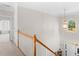 Bright stairway featuring wood banister and pendant lighting viewed from the top of the stairs at 152 Vinings Lake Ct, Mableton, GA 30126
