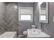 Bathroom with grey wall, herring bone tile accent, glass bowl sink, and modern fixtures at 2248 Doris Dr, Decatur, GA 30034