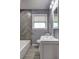 Bathroom with grey wall, herring bone tile accent, glass bowl sink, and modern fixtures at 2248 Doris Dr, Decatur, GA 30034