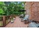 Spacious deck area showcasing comfortable seating and an umbrella, surrounded by a lush, wooded landscape at 2930 Monticello Dr, Cumming, GA 30041