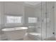 Bright bathroom featuring a glass shower, soaking tub, and patterned window at 2930 Monticello Dr, Cumming, GA 30041