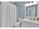 Well-lit bathroom with white tile, a modern sink, and a shower with a white curtain at 2930 Monticello Dr, Cumming, GA 30041
