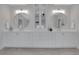 Bright bathroom featuring double vanity with modern fixtures, large mirrors, and marble flooring at 2930 Monticello Dr, Cumming, GA 30041
