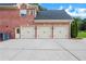 Three-car garage offers ample parking and storage space, complementing the brick exterior and well-manicured lawn at 2930 Monticello Dr, Cumming, GA 30041