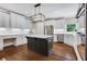 Modern kitchen featuring white cabinets, a dark island, stainless steel appliances, and hardwood floors at 2930 Monticello Dr, Cumming, GA 30041