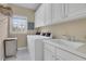Functional laundry room with a sink, washer, dryer, and ample cabinet space for organization at 2930 Monticello Dr, Cumming, GA 30041