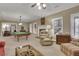 Expansive living area showcasing a fireplace, plush seating, a pool table, and ample natural light at 2930 Monticello Dr, Cumming, GA 30041