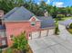 Brick home featuring a three car garage and well-maintained landscaping at 2930 Monticello Dr, Cumming, GA 30041