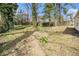 Expansive backyard with mature trees, a mix of grass and ground cover, and a partial fence at 3197 Church St, Atlanta, GA 30344