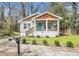Charming home featuring a welcoming front porch, brick foundation, manicured bushes, and wood accents at 3197 Church St, Atlanta, GA 30344