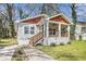 Inviting home boasting a covered front porch, wooden steps, manicured bushes, and unique architectural accents at 3197 Church St, Atlanta, GA 30344