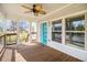 Bright front porch featuring wood floors, modern railings, ceiling fan, and a vibrant blue front door at 3197 Church St, Atlanta, GA 30344