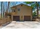Three-car garage with a view of second story balcony and wooded surroundings at 3292 Holly Mill Ct, Marietta, GA 30062