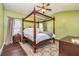 The bedroom features a four poster bed, wood floors, and neutral-colored walls at 409 Hunting Ridge Way, Ellenwood, GA 30294