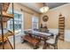 Charming breakfast nook features a rustic wooden table, bench seating, shelving, and ample natural light from two windows at 409 Hunting Ridge Way, Ellenwood, GA 30294
