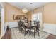 Elegant dining room features a stylish chandelier, dark wood table with seating for eight, and decorative wainscoting at 409 Hunting Ridge Way, Ellenwood, GA 30294