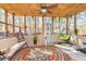 The sunroom features a wooden ceiling, hanging swing, and large windows overlooking the backyard at 409 Hunting Ridge Way, Ellenwood, GA 30294
