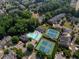 A stunning aerial view of a community with pool, tennis courts, and pond amidst lush green trees and manicured lawns at 4406 Kendall Way, Roswell, GA 30075