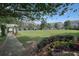 Beautifully landscaped green space featuring a pergola, manicured lawn, colorful flowers, and well-maintained bushes at 4406 Kendall Way, Roswell, GA 30075