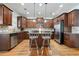 Charming kitchen features an island with seating, granite countertops, stainless steel appliances, and wooden cabinetry at 4406 Kendall Way, Roswell, GA 30075