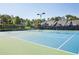 Well-maintained tennis courts with blue and green surfaces, surrounded by trees and fencing at 4406 Kendall Way, Roswell, GA 30075