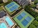 Aerial view of tennis courts and a swimming pool surrounded by lush landscaping and well-maintained grounds at 4406 Kendall Way, Roswell, GA 30075