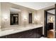 Modern bathroom featuring double sinks, marble countertop, dark cabinets, and wallpaper at 2660 Peachtree Nw Rd # 26F, Atlanta, GA 30305