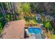 Aerial view showcasing a lovely home with a pool and beautifully landscaped backyard at 5494 Princeton Oaks Ln, Sugar Hill, GA 30518