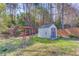Backyard featuring a storage shed and an arbor in a grassy yard at 5494 Princeton Oaks Ln, Sugar Hill, GA 30518