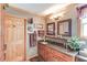 Bathroom with wood cabinets, granite countertop, double mirrors, and towel racks at 5494 Princeton Oaks Ln, Sugar Hill, GA 30518