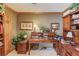 Cozy office space with wood desk, built-in shelves, and natural light at 5494 Princeton Oaks Ln, Sugar Hill, GA 30518